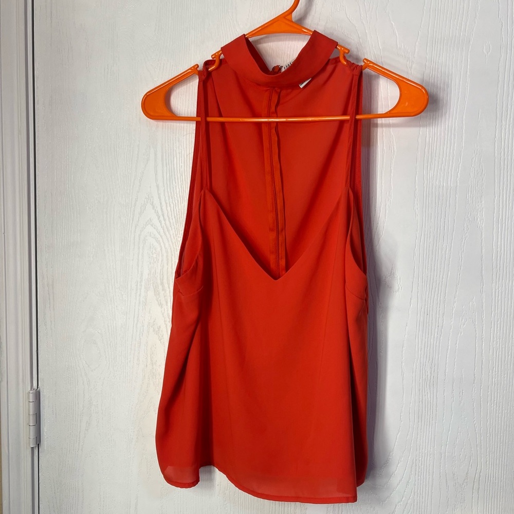 Orangey red sleeveless blouse with mock neck and back zipper closure